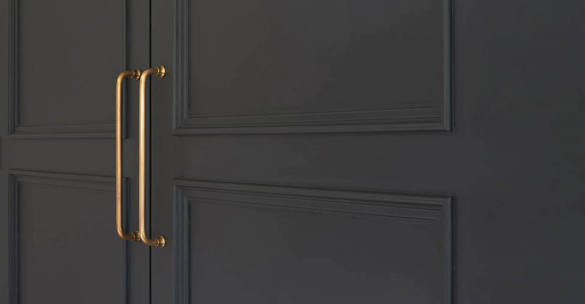 Poignées de porte en laiton ancien Corston sur porte noire